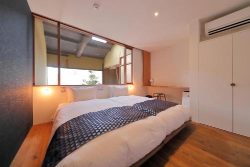a bedroom with a large bed with a large window at Kyo no oozora FUKA in Kyoto