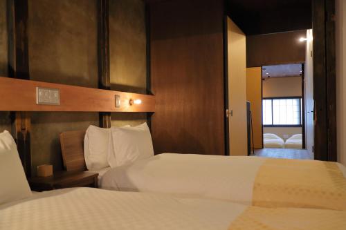 a hotel room with two beds and a window at Kyo no oozora FUKA in Kyoto