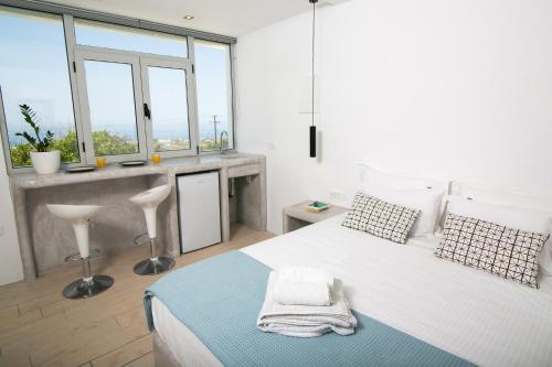 biała sypialnia z dużym łóżkiem i oknami w obiekcie Sensia Studio with Sea View w mieście Oia