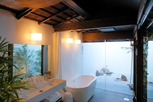 a bathroom with a tub and a sink and a shower at Kyo no oozora FUKA in Kyoto