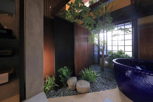 a bathroom with a large blue bowl with plants in it at Kyo no oozora FUKA in Kyoto