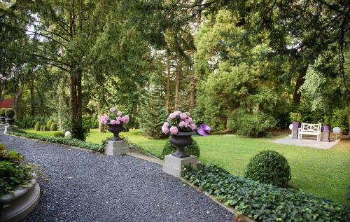 a garden with two vases filled with pink flowers at Park Villa Hotel in Wuppertal