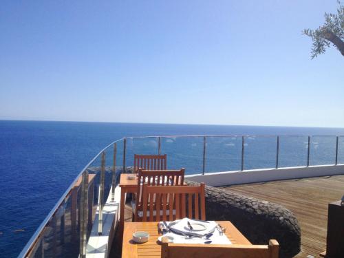 a table and two chairs on a balcony overlooking the ocean at Madeira Regency Cliff - Adults Only in Funchal