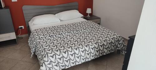 a bedroom with a bed with a black and white comforter at La dimora di Roberto in Santeramo in Colle