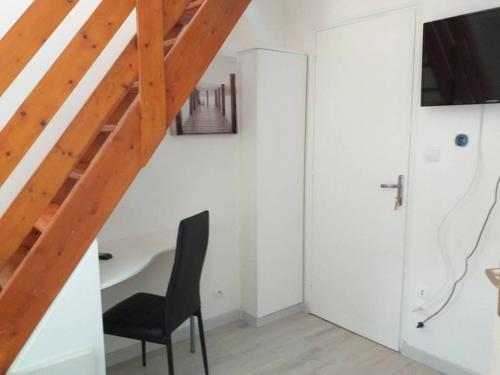 een kamer met een bureau, een stoel en een trap bij Au calme sur le port de plaisance et le GR34 in Plérin