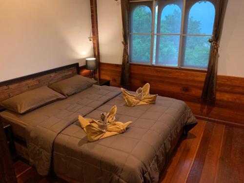 トン・ナイ・パン・ノイにあるThe Hill Villageのベッドルーム1室(金の枕が付いたベッド2台付)