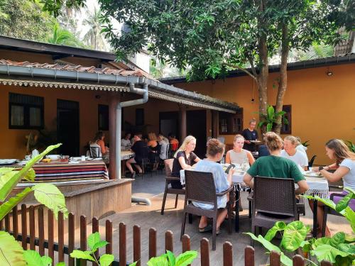 a group of people sitting at tables at a restaurant at Nature's Hideout Holiday Home in Mirigama