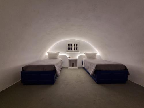 Cette chambre blanche comprend 2 lits. dans l'établissement Villa Angelica, à Perivolos