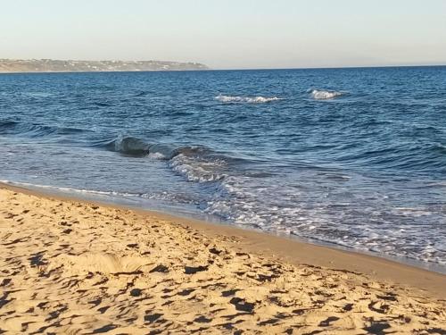 una spiaggia sabbiosa con onde nell'oceano di casaaugello a Menfi