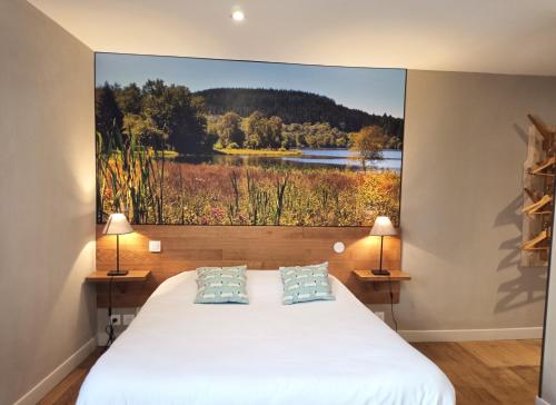 1 dormitorio con 1 cama y una gran pintura en la pared en Le Relais des Lacs, en Planchez