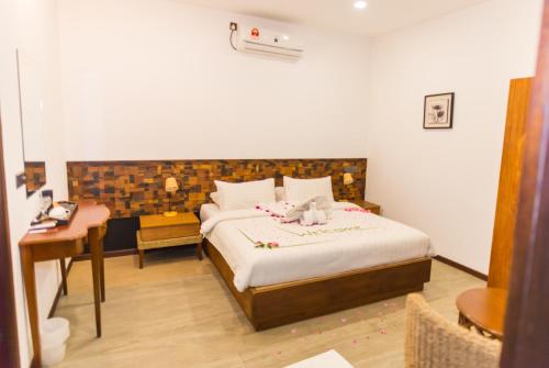 a bedroom with a bed with a teddy bear on it at Premier Beach in Gulhi