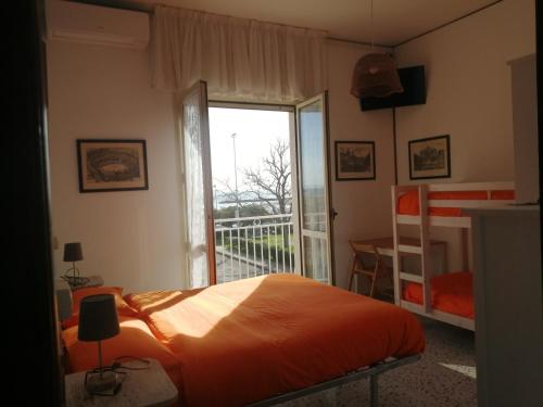 a bedroom with an orange bed and a balcony at B&B GALLETTO in Porto San Giorgio