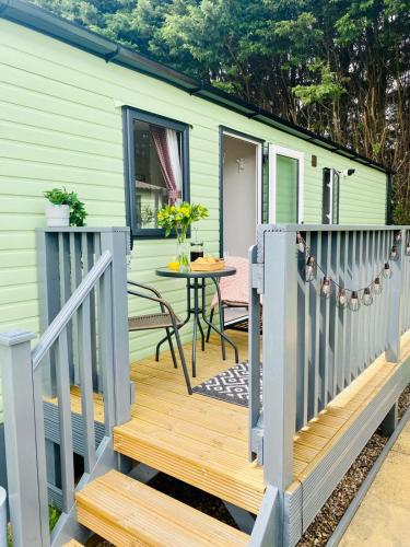 a tiny house with a deck with a table at Nook on the Nidd, Knaresborough in Knaresborough