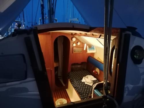 um pequeno quarto com uma cama num barco em Voilier de charme à quai em Saint-Raphaël