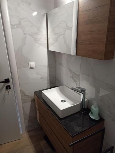 a bathroom with a white sink and a mirror at Paparoúna 5 min from beach in Nikiti