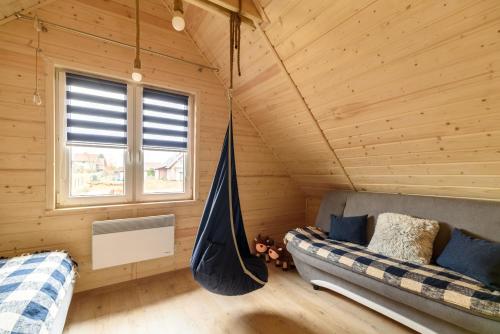 una habitación con una hamaca en una cabaña de madera en Brzozowy Zakątek, en Dziemiany