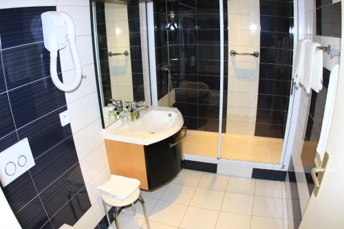 a bathroom with a sink and a shower at Hotel de la Basilique in Paray-le-Monial