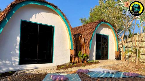 een klein huis met een rieten dak bij Love Shack Hostel & Cafe in San Juan