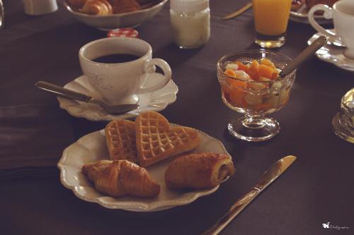 a table with a plate of bread and a cup of coffee at maison d'hôtes Le Courty in Blousson-Sérian