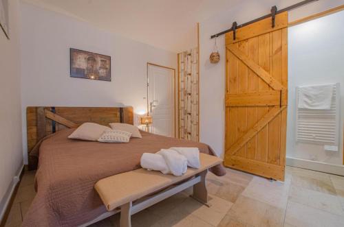 a bedroom with a large bed with a wooden door at L'instant... in Marolles-sous-Lignières