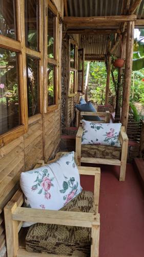a room with two beds in a cabin with windows at Backyard Hostel in Moshi