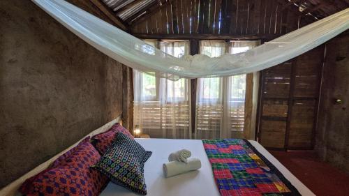a bedroom with a bed in a room with a window at Backyard Moshi Eco Bungalows in Moshi