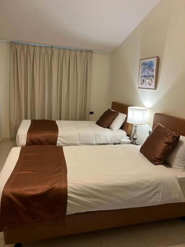 a hotel room with two beds and a window at فندق قوافل الشام in Tabuk