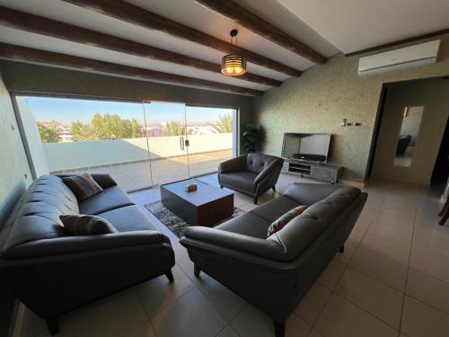 a living room with two couches and a television at اجنحة مجمع القوافل الفندقيه in Tabuk