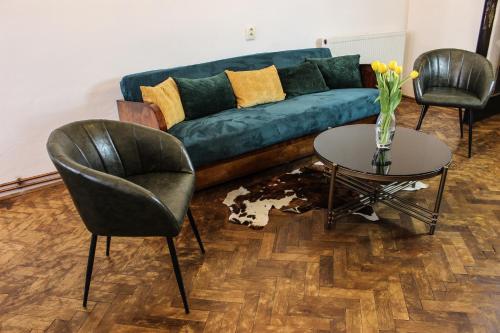 a living room with a couch and two chairs and a table at Roth´s Apartment in Košice