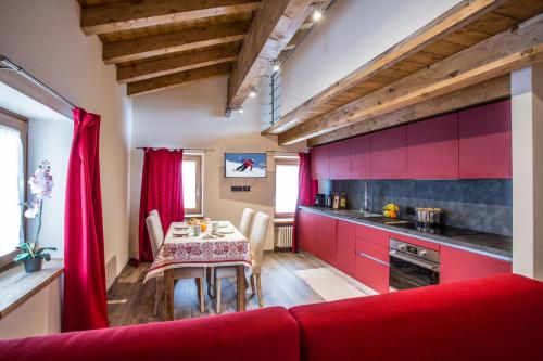 a kitchen with a table and a red couch at Esprit Carrel in Valtournenche