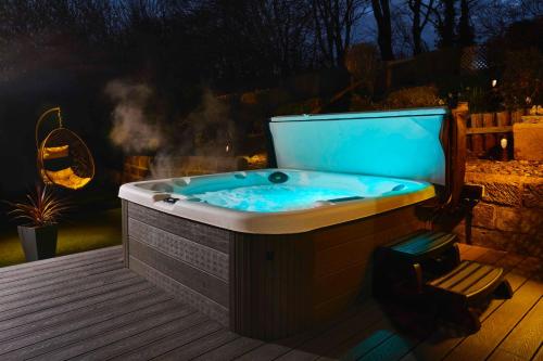 a jacuzzi tub sitting on a deck at night at Popular with families - Cinder Hill in Whitby