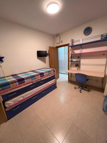 a bedroom with a bed and a desk and a chair at Appartamento Modugno centro (Bari) in Modugno