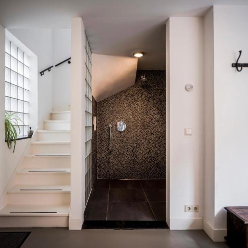 a hallway with white walls and stairs and a wall at Romantic Wellness BnB Noordwijk in Noordwijk aan Zee