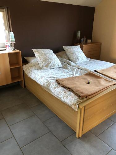 a bedroom with a large bed with two pillows at « En toute simplicité chez Fabienne et Bruno » in Waimes