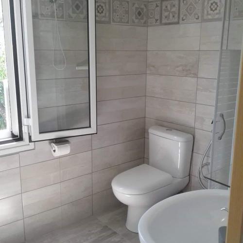 a white bathroom with a toilet and a sink at San Giorgio in Gaios
