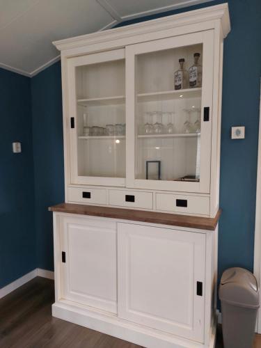 a white hutch in a bathroom with a toilet at Modern en chic chalet tot 4 personen op de Veluwe Recreatiepark De Oude Driest - All inclusive in Putten