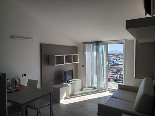 a living room with a couch and a table and a television at Hotel Residence Sanremo in Grado