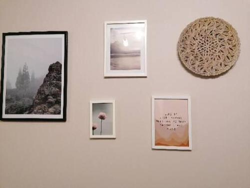 a wall with framed photographs on a white wall at Apartman_Krstić_1 in Subotica
