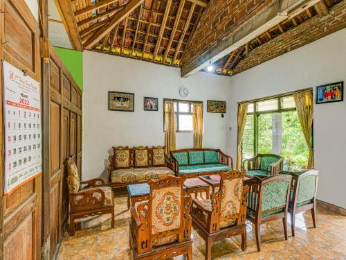 uma sala de jantar com uma mesa e cadeiras num quarto em OYO Homes 90987 Desa Wisata Gabugan Syariah em Balong