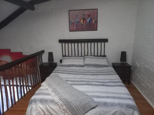 ein Schlafzimmer mit einem großen Bett mit einem Holzrahmen in der Unterkunft BARRY MICASA SELF CATERING ACCOMMODATION in Port Elizabeth