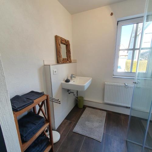 a bathroom with a sink and a mirror at Alte Backstube - Ferienwohnung Hüttenstube und Ferienzimmer Auszeit in Erkenbrechtsweiler
