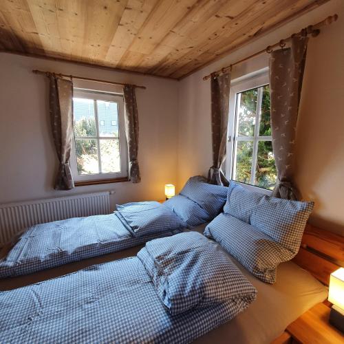 a bedroom with three beds and two windows at Alte Backstube - Ferienwohnung Hüttenstube und Ferienzimmer Auszeit in Erkenbrechtsweiler