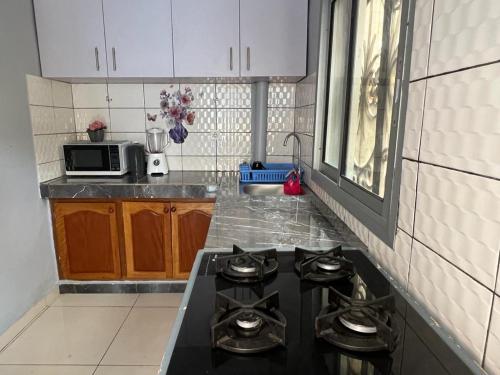 a kitchen with a stove top oven in a kitchen at Appartement meublé haut standing Bonamoussadi (Kotto) in Douala