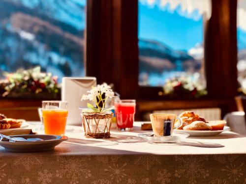 a table with plates of food and drinks on it at Hotel Piccolo Chalet in Claviere