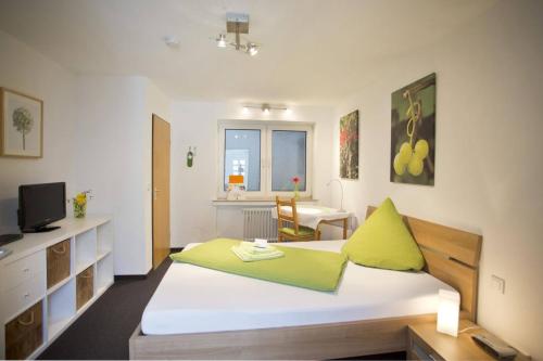 Hotel Emmerich في وينينغين: غرفة نوم بسرير ومكتب وتلفزيون