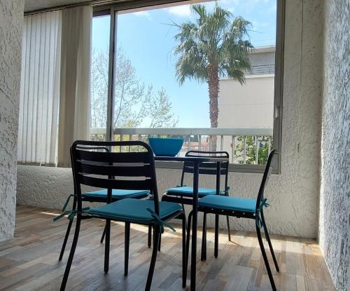 une table et des chaises dans une pièce avec un palmier dans l'établissement Grand T3 Lumineux Spacieux Propre, tout confort, Parking, Ascenseur, Emplacement central unique, port-commerces-mer et plages à pied, Location du Samedi au Samedi, à Sanary-sur-Mer