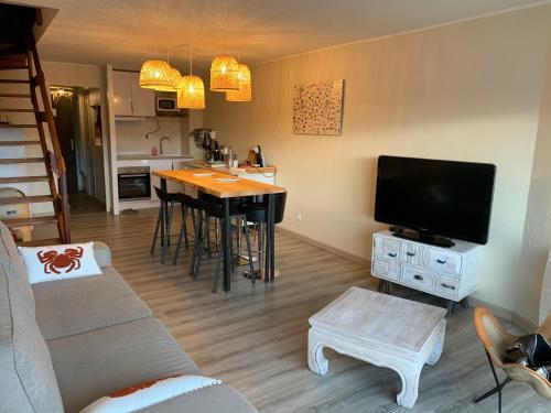 un salon avec un canapé et une table avec une télévision dans l'établissement Fort-Mahon Plage : Superbe appartement vue mer, à Fort-Mahon-Plage