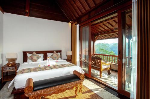 - une chambre avec un lit et un balcon dans l'établissement Campuhan Sebatu Resort, à Tegalalang