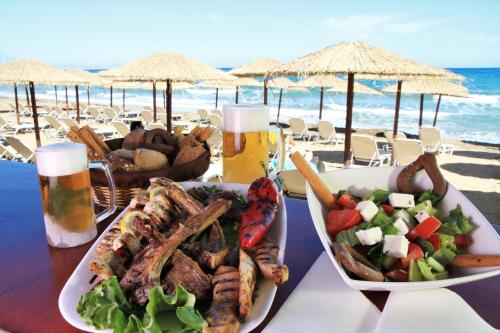 a table with a plate of food on the beach at Dedalos Beach Hotel in Sfakaki