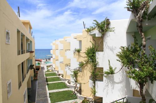 an alley between buildings with the ocean in the background at Dedalos Beach Hotel in Sfakaki